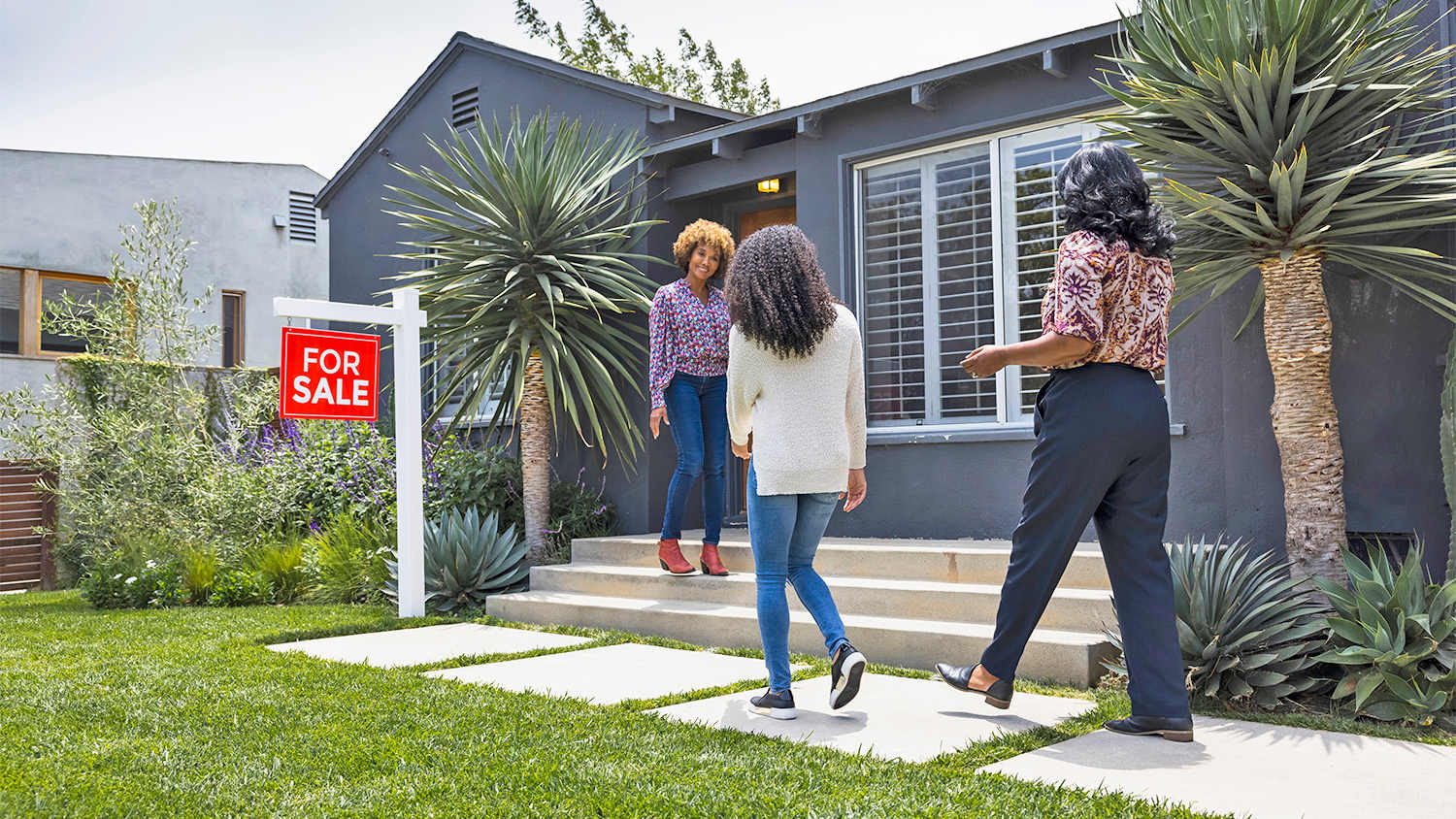 woman greeting people for a house tour