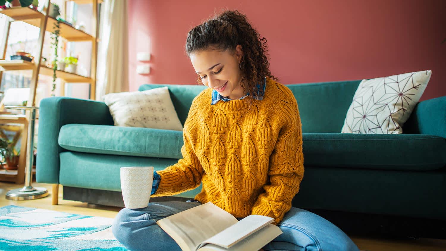 woman drinking coffee and reading a book