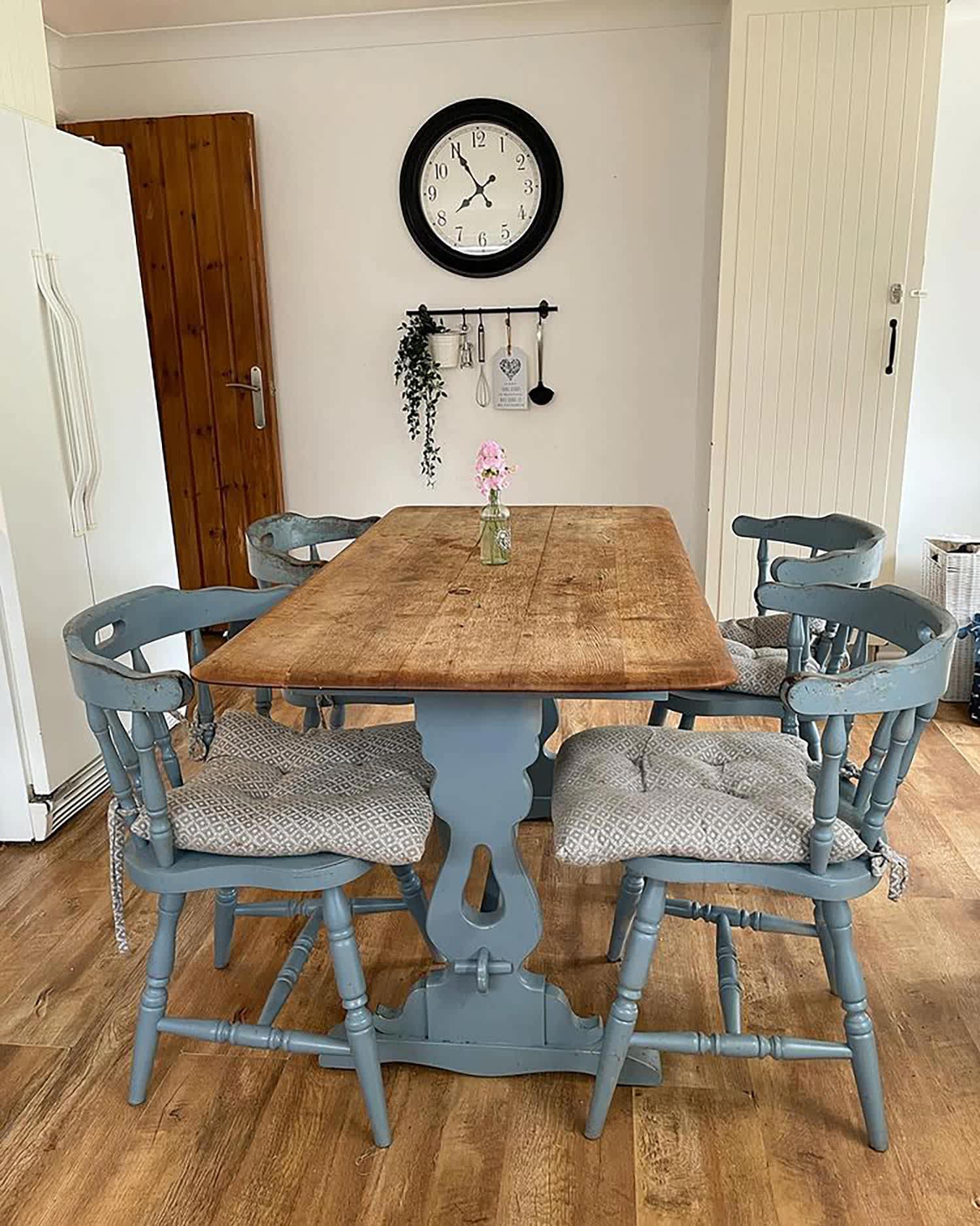 A wooden dining table and blue slate painted chairs