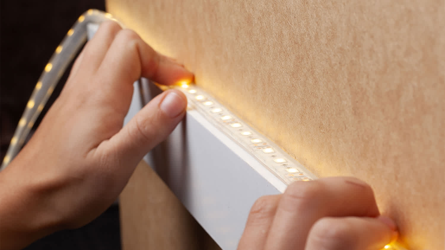 A woman’s hands installing LED strip lights