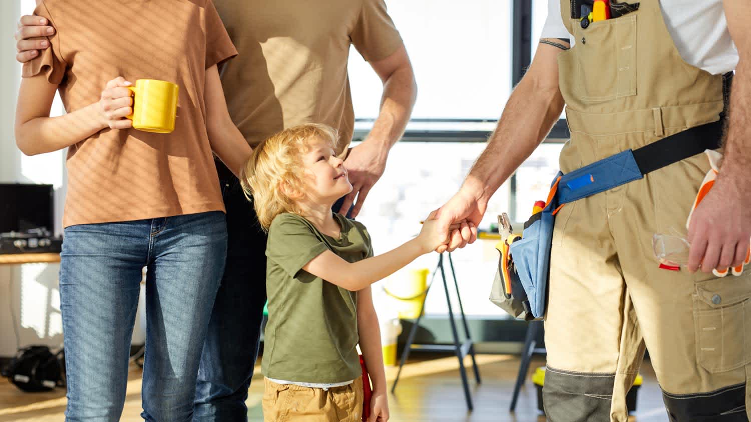 The son of a family shaking hands with a contractor