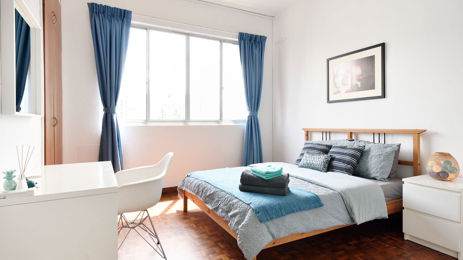 A clean and modern bedroom with long curtains on short windows