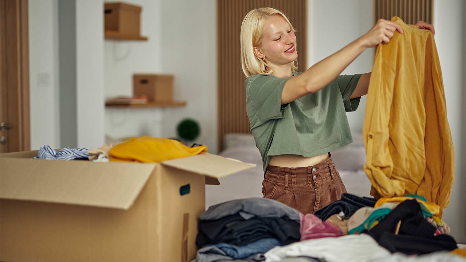 woman folding clothes to donate
