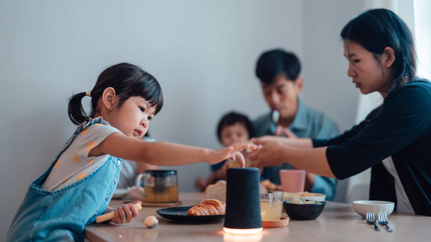 A young girl using a smart speaker