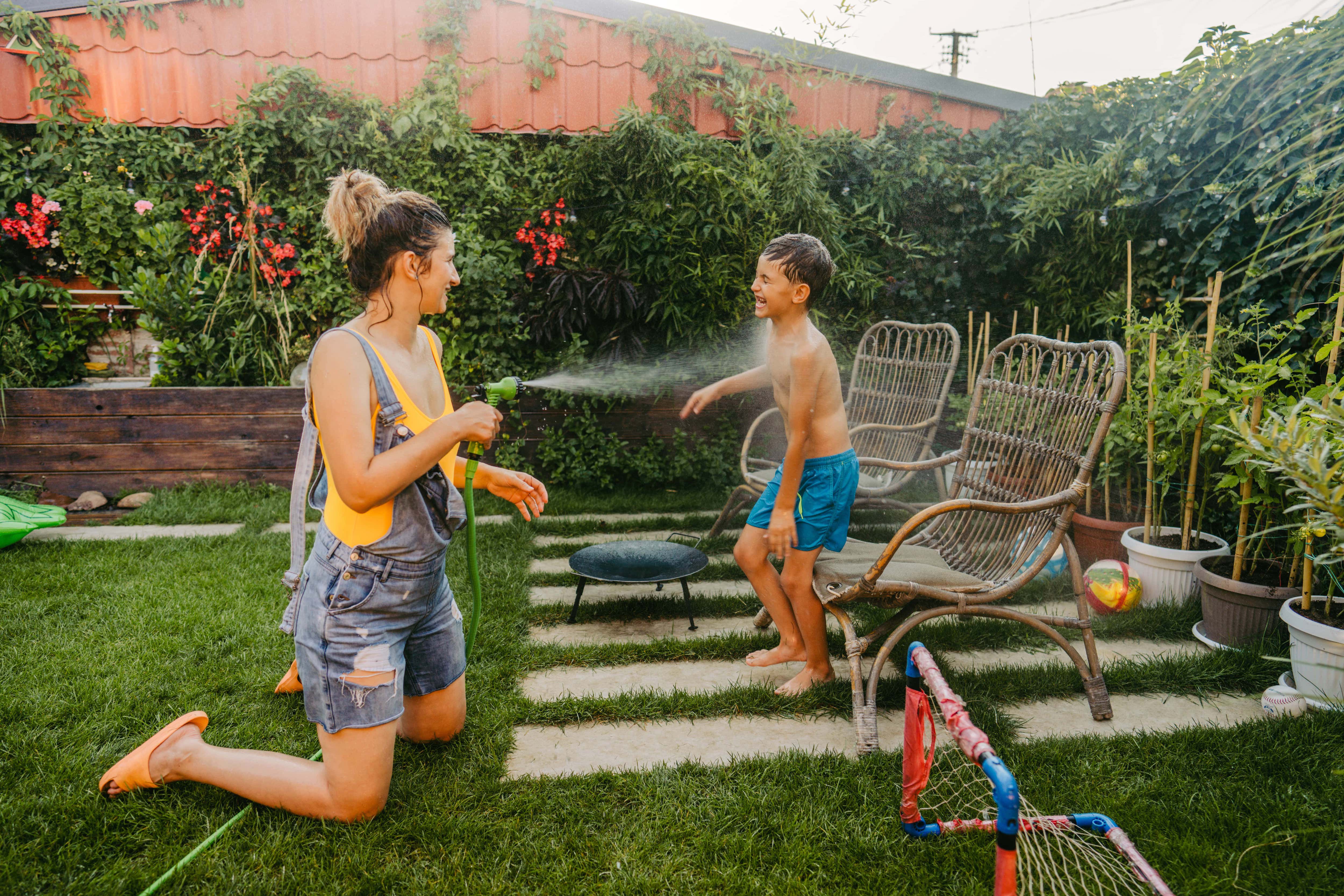 Mother and son playing with hose outside