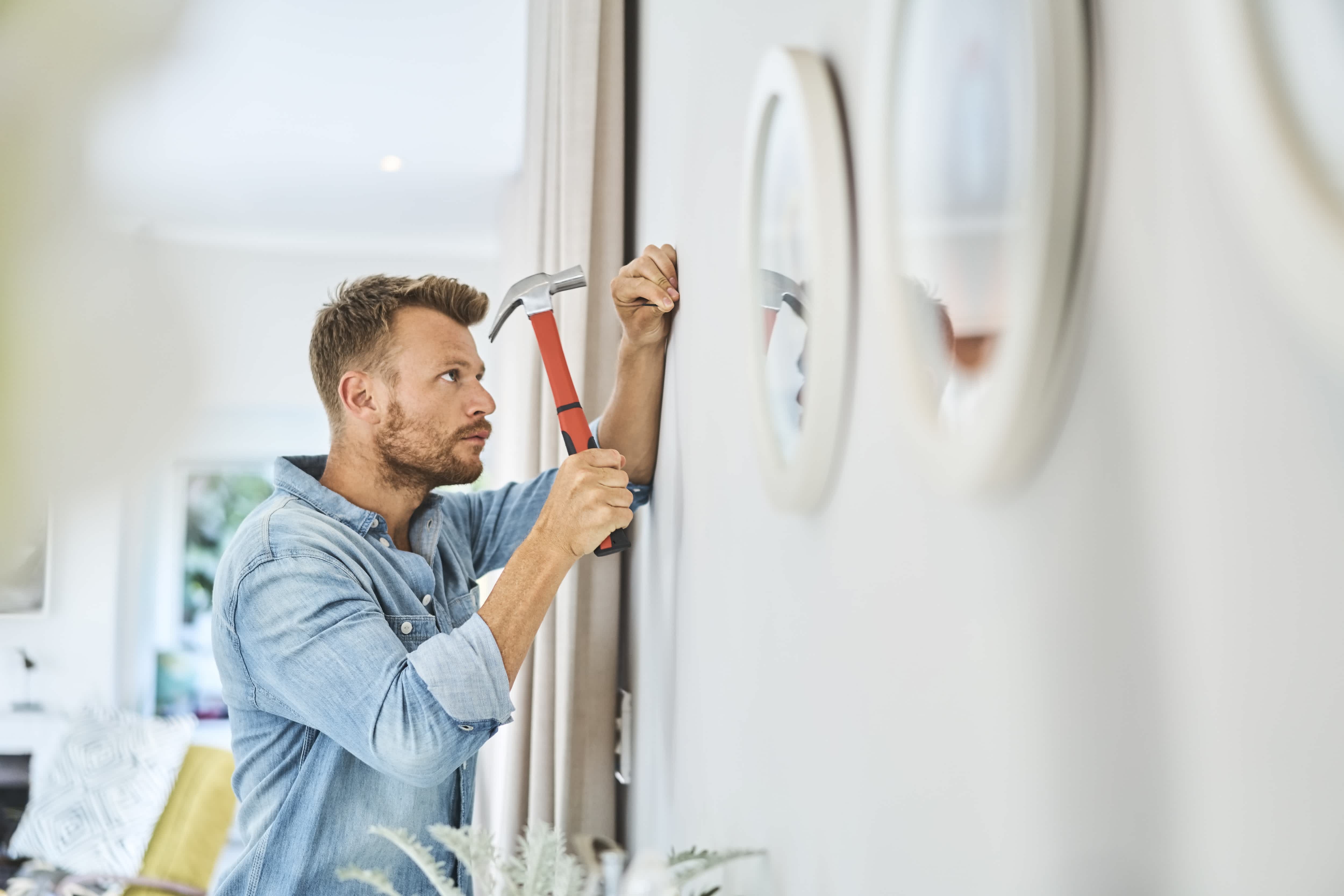 Man hammering a nail into the wall