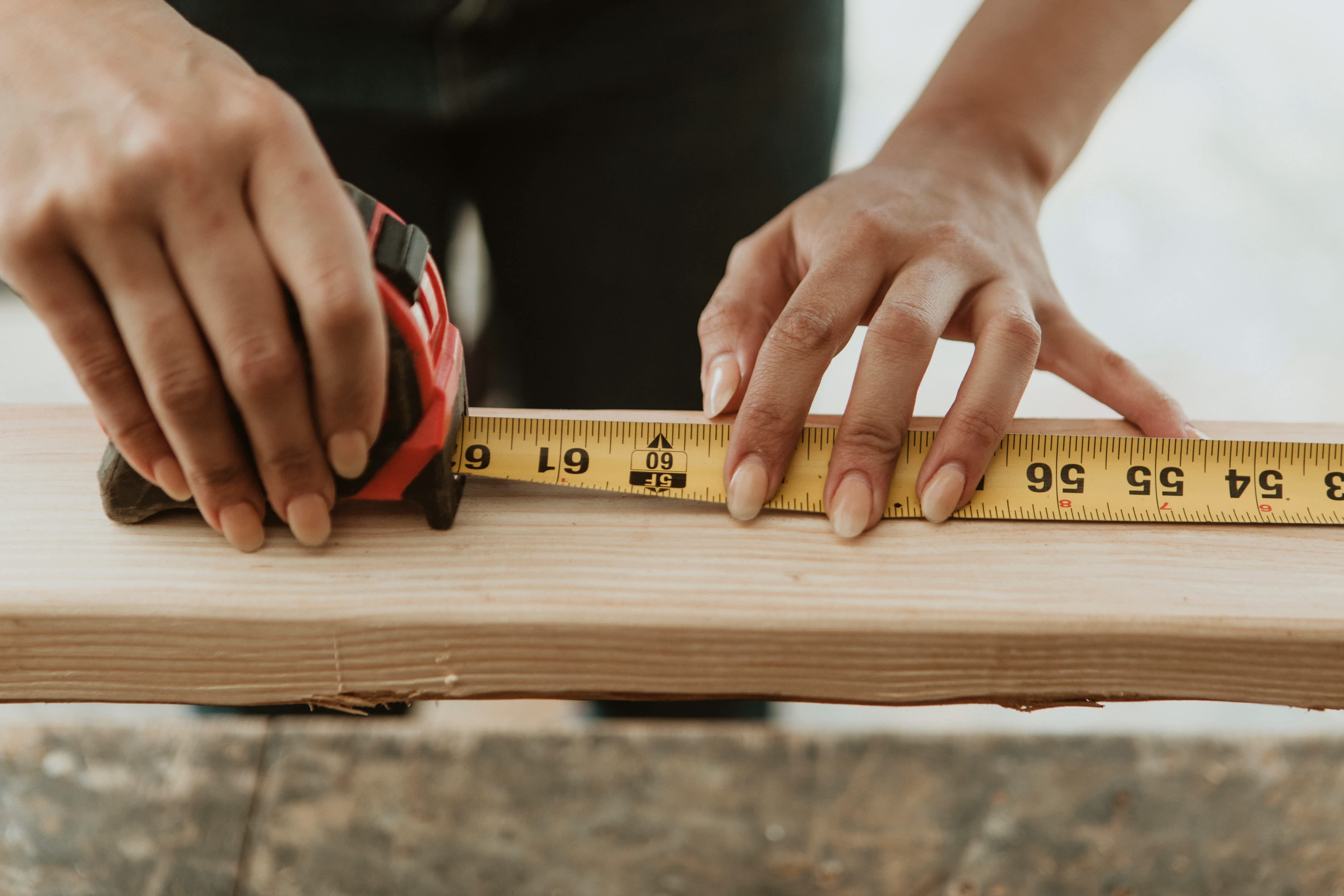 Woman using imperial units tape measure