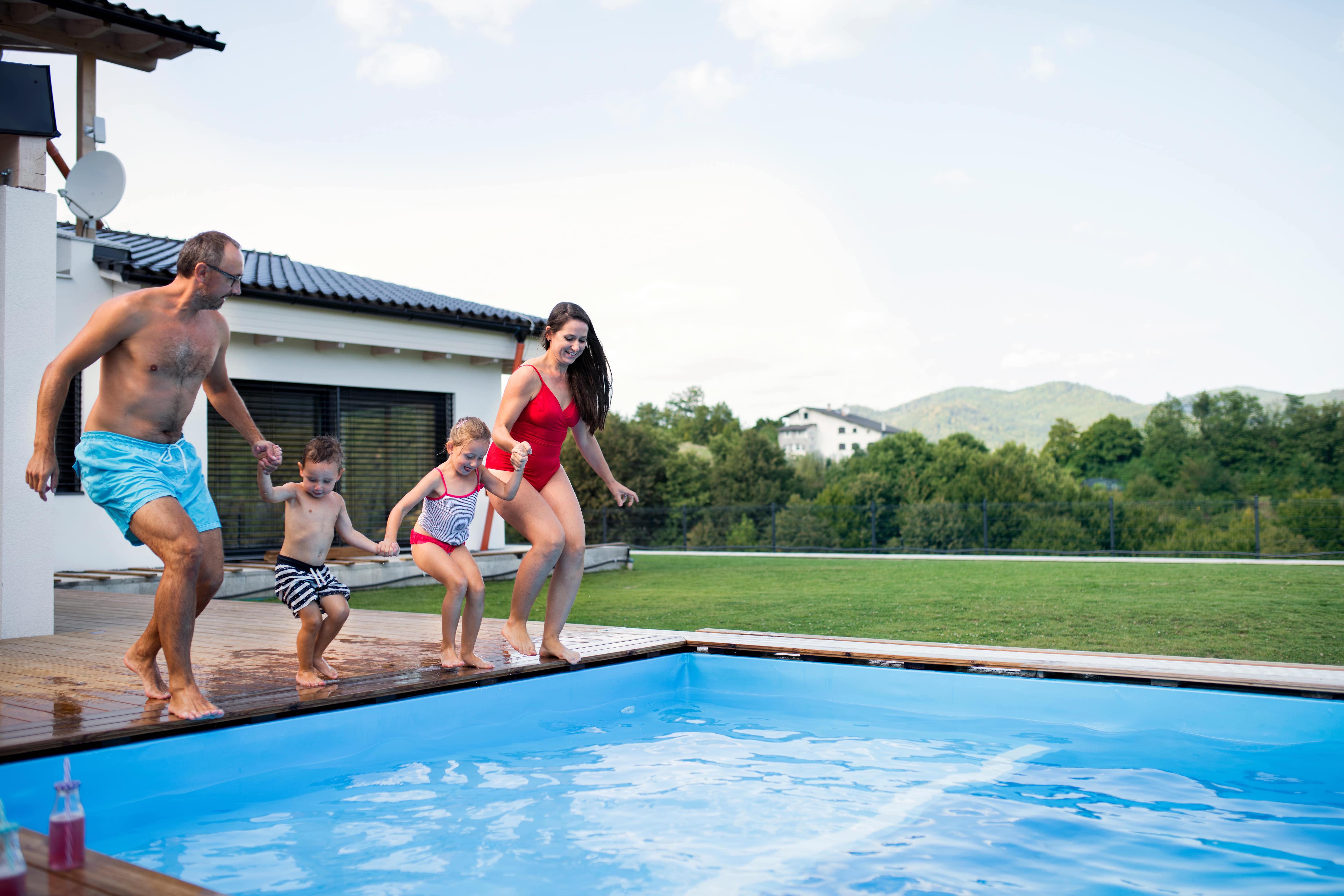 Family jumping into outdoor pool
