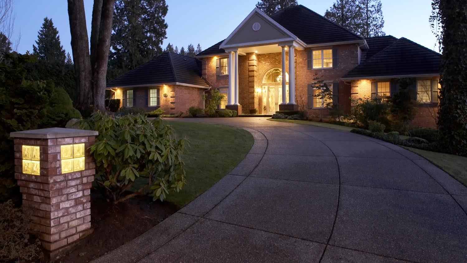 The exterior of a house with an illuminated driveway