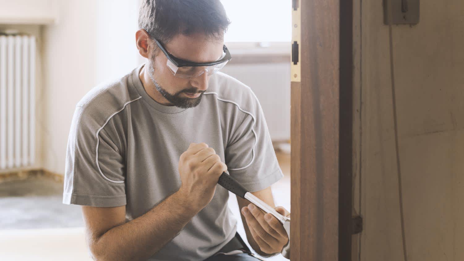 Man removing an old door at home