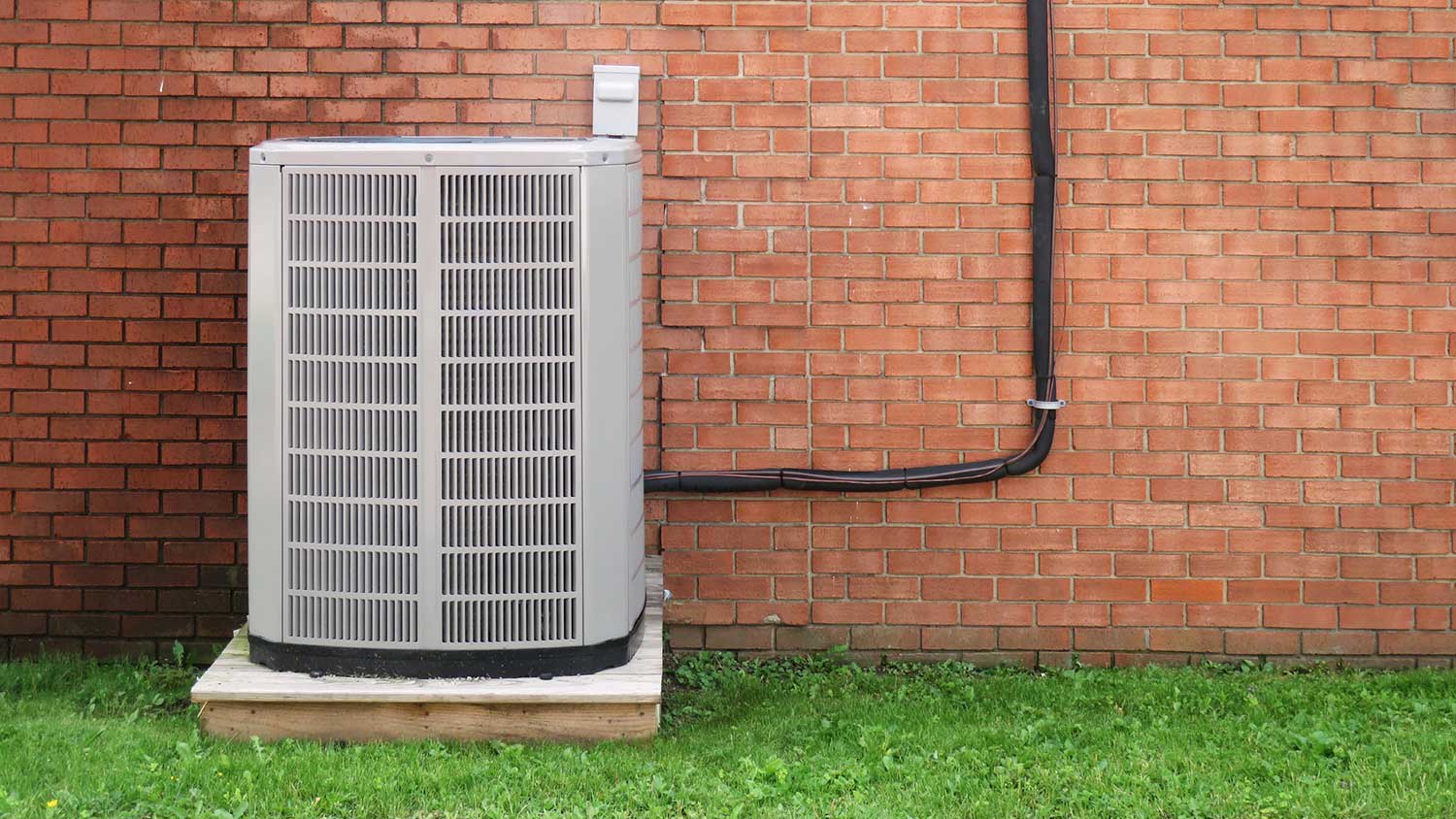 Air conditioner unit outside of a brick house