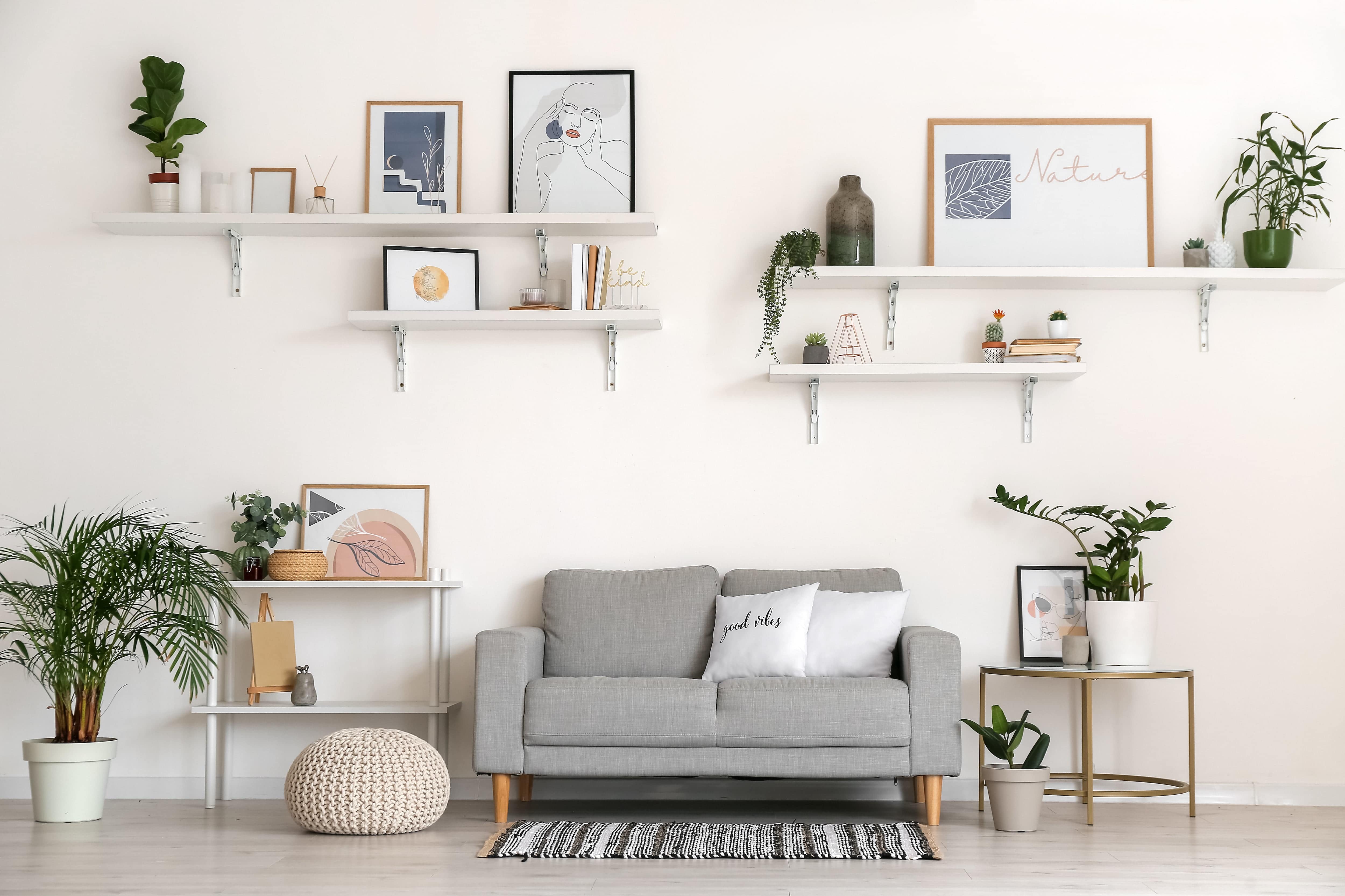 Gray couch with decorated hanging shelves in the background