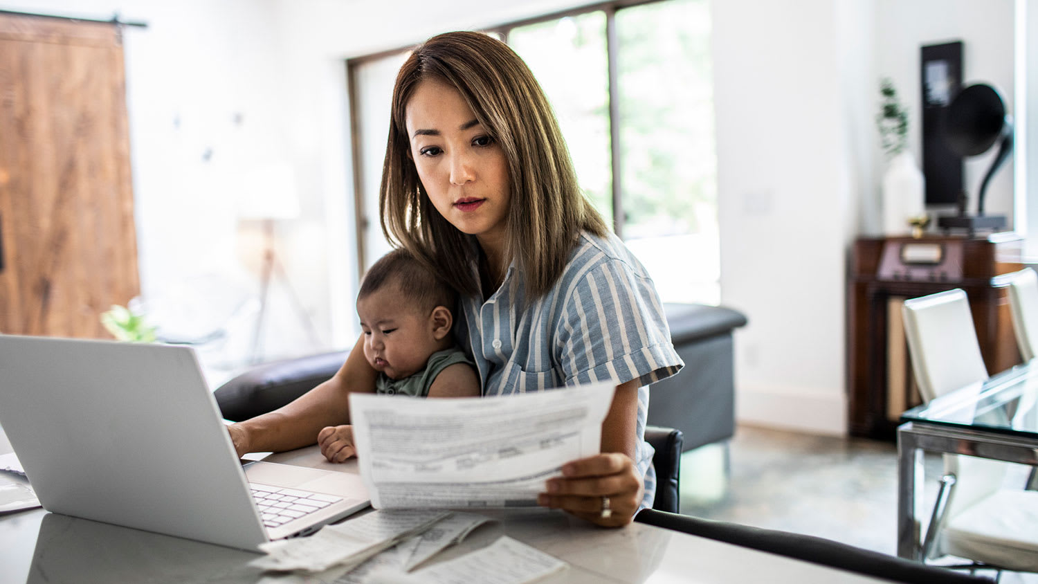 Mother working while holding her baby
