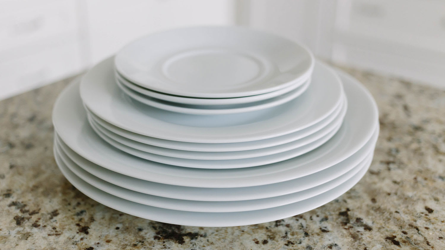 White plates stacked on kitchen counter