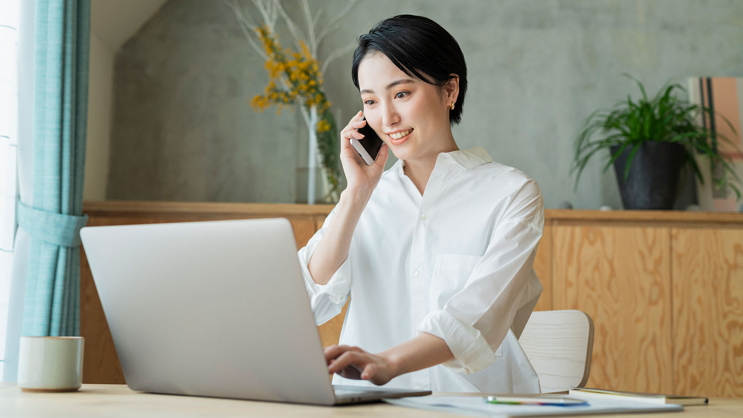 Woman on the phone using laptop