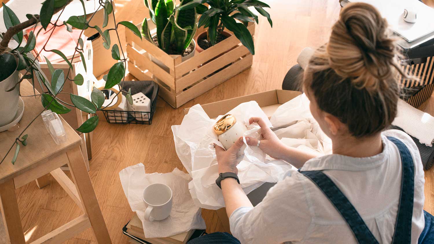 woman sitting on the floor packing her belongings