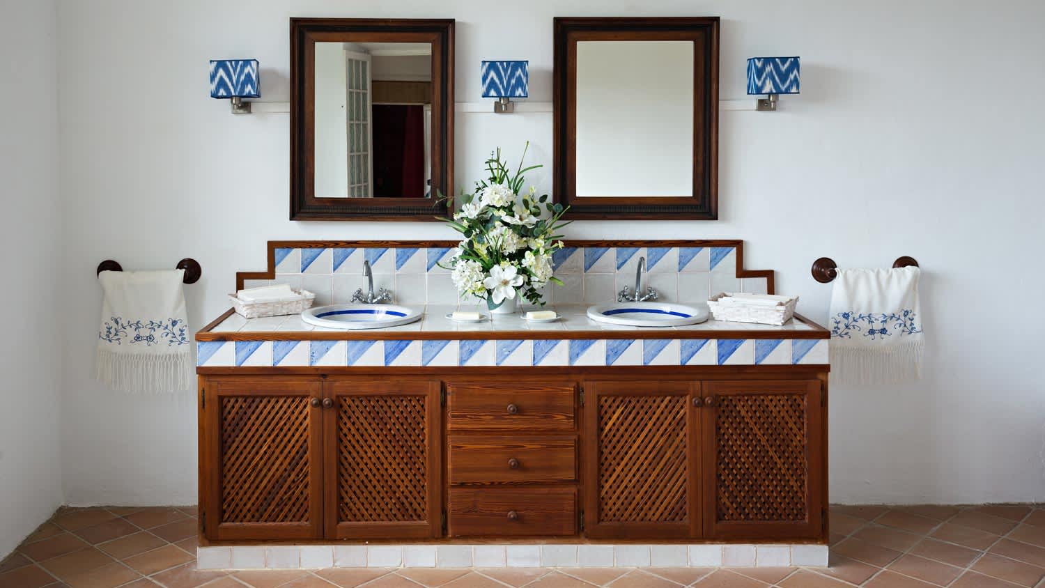 A wooden vanity with blue and white tiles