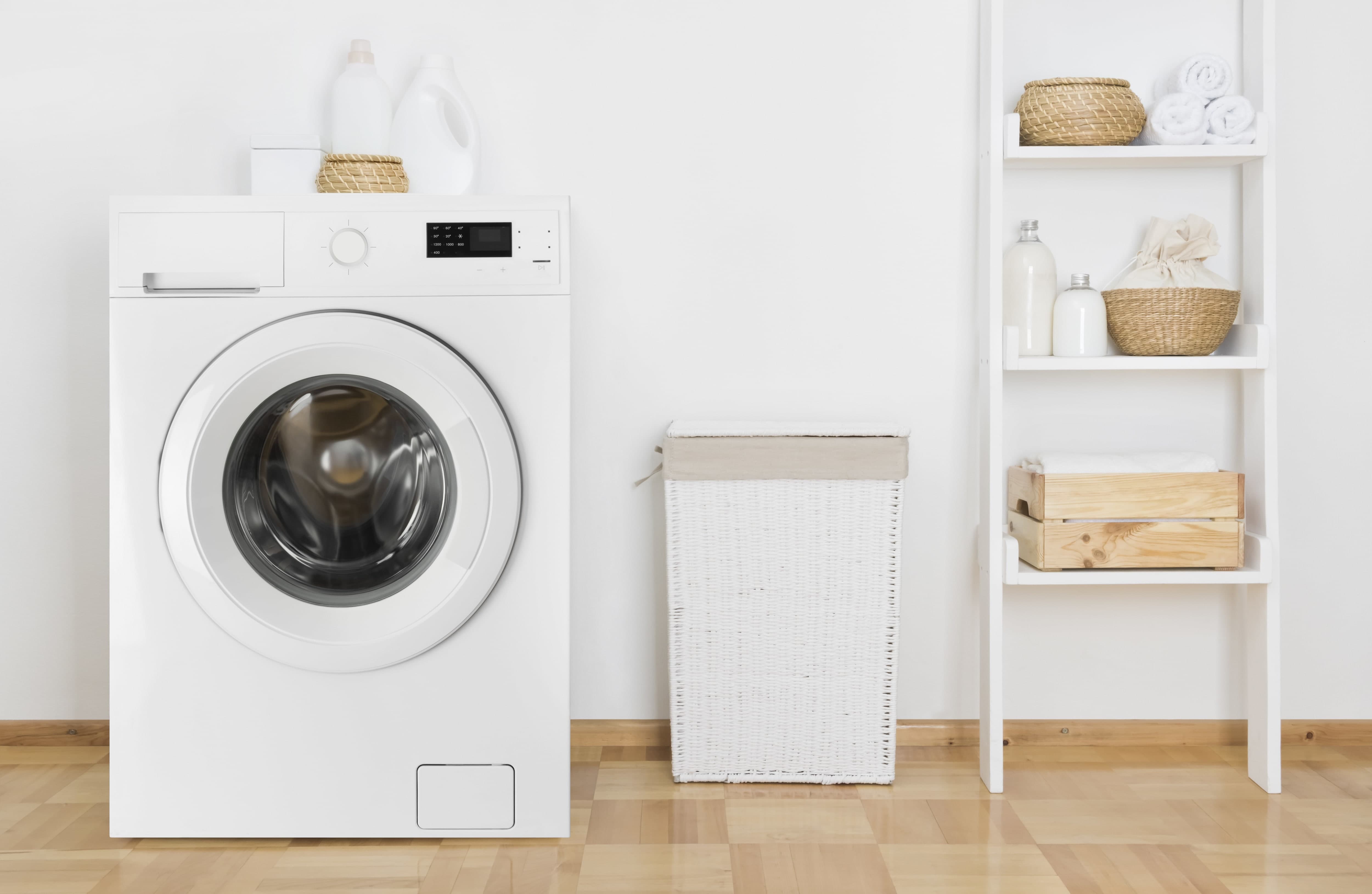Washing machine next to tall shelving unit