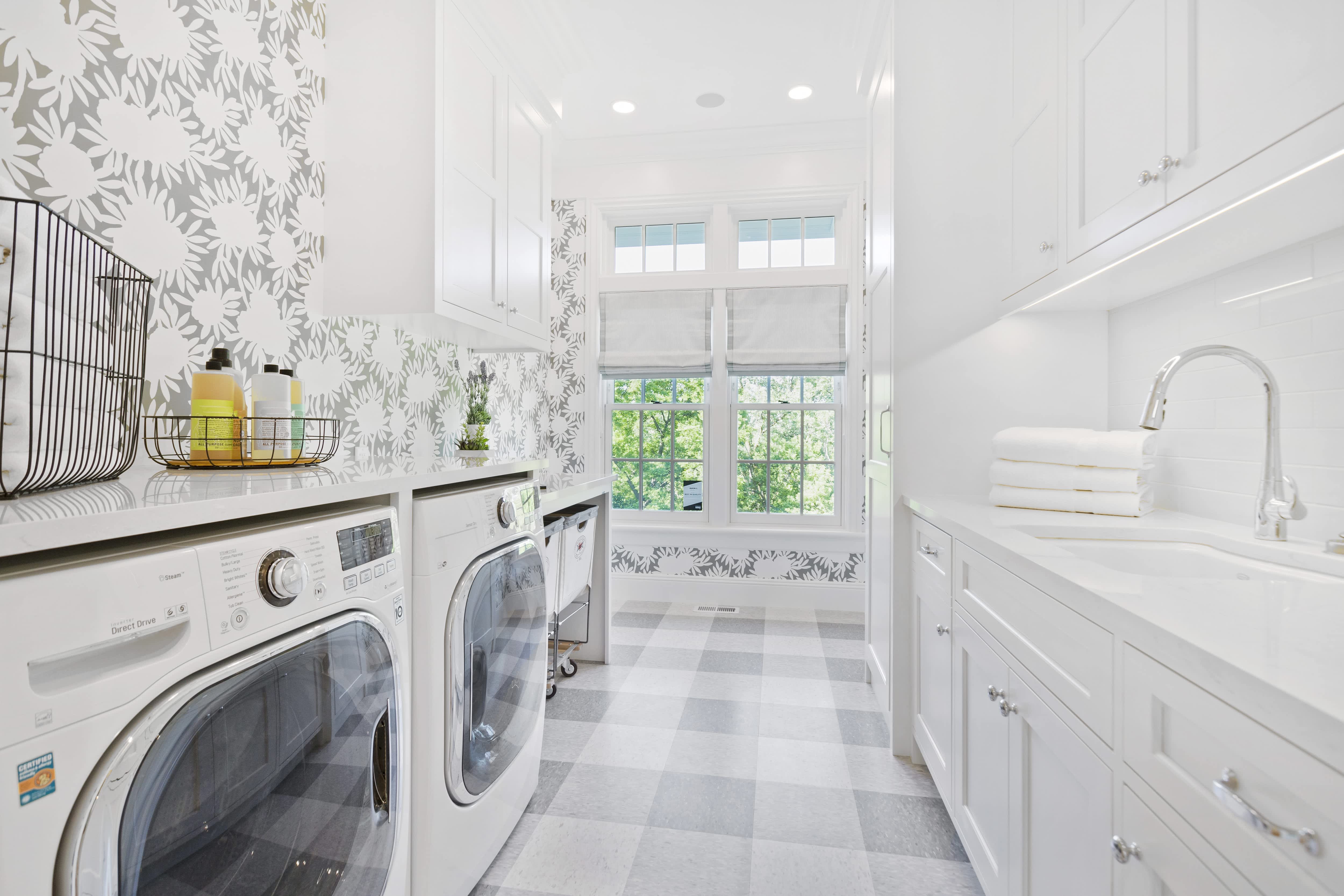 Laundry room with decorative wallpaper and flooring