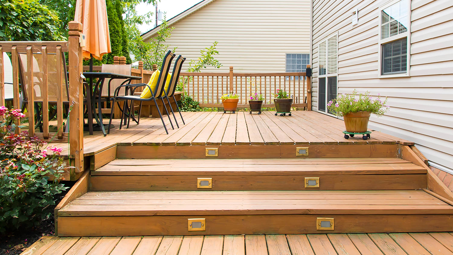 Wooden deck in backyard with steps