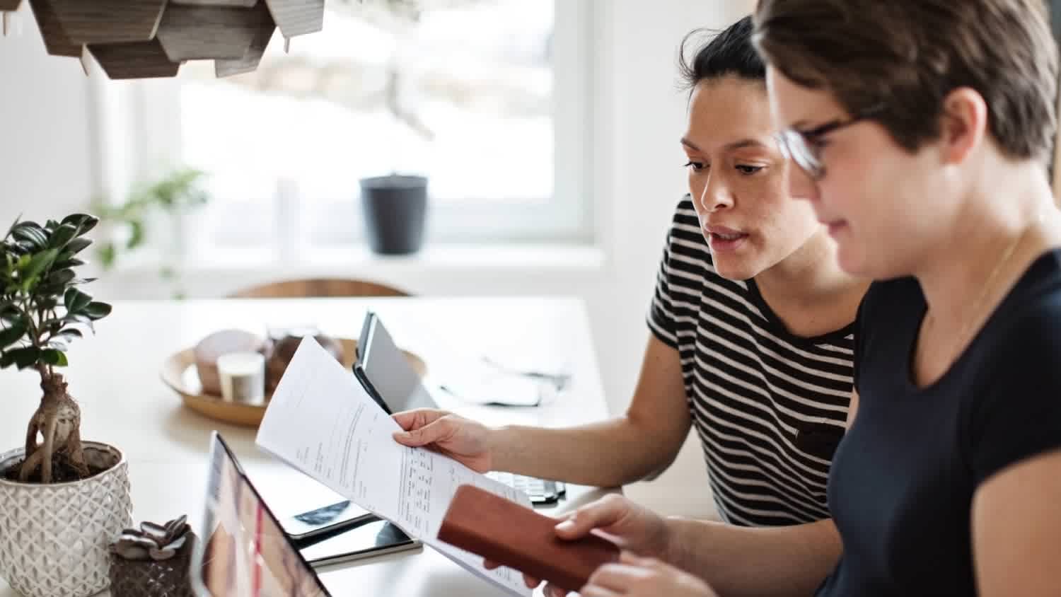 A couple discussing over financial bills while using laptop at table
