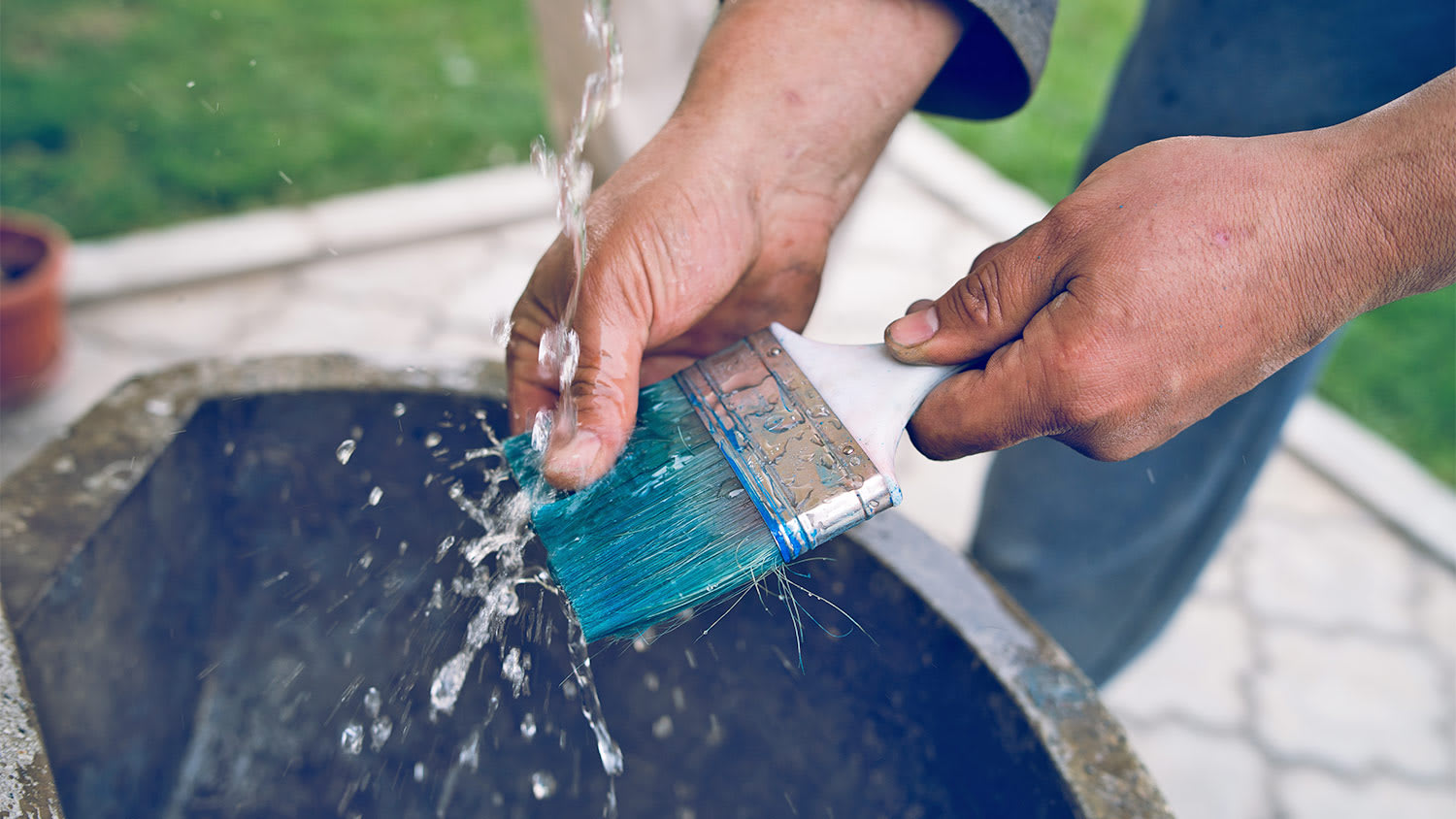 Man washing brush blue paint