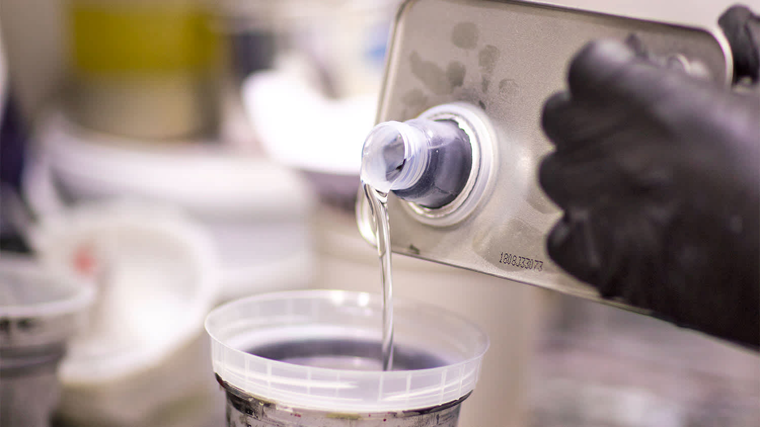 Pouring clear liquid with gloves