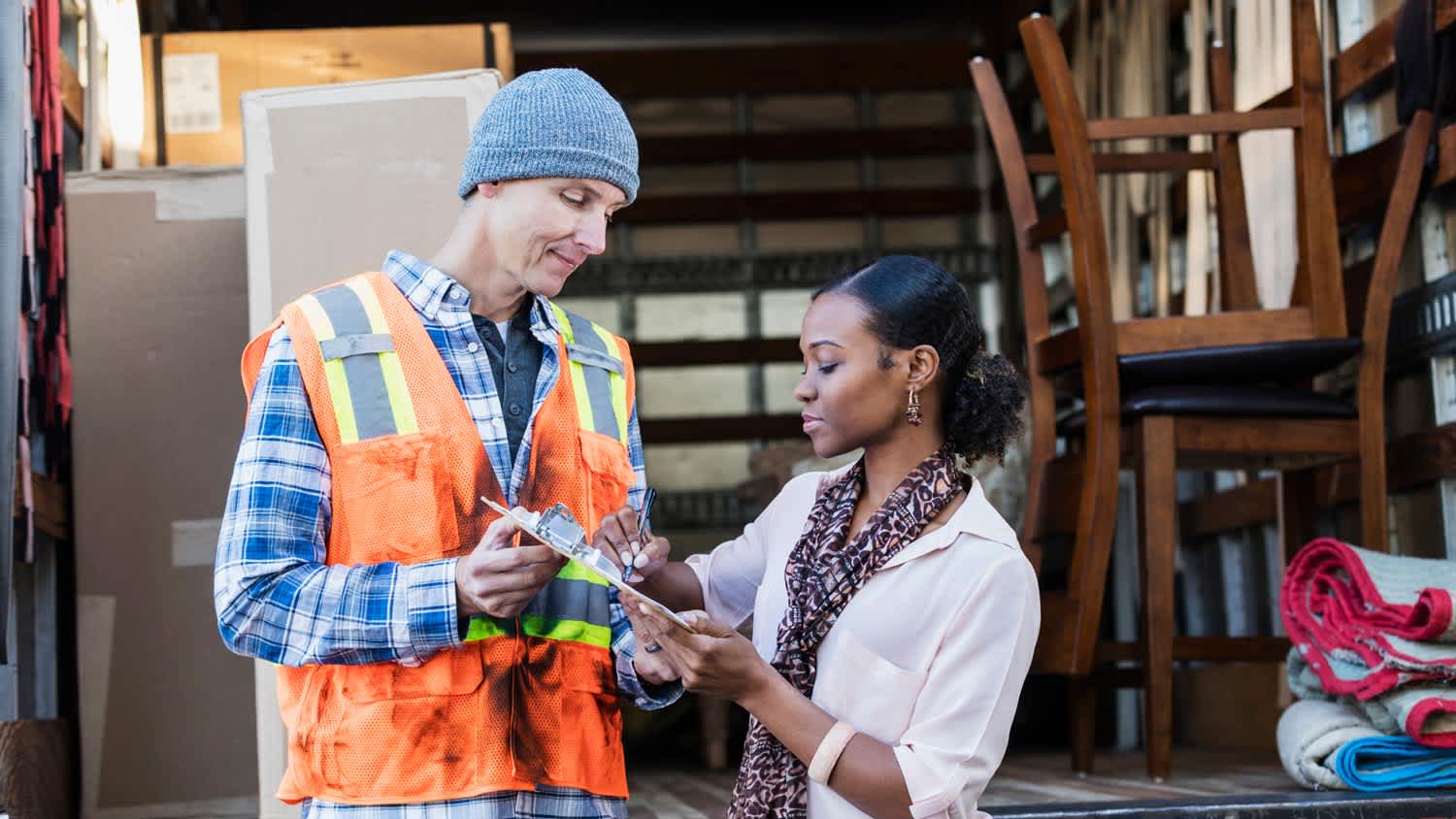 A homeowner signing paperwork with the moving company