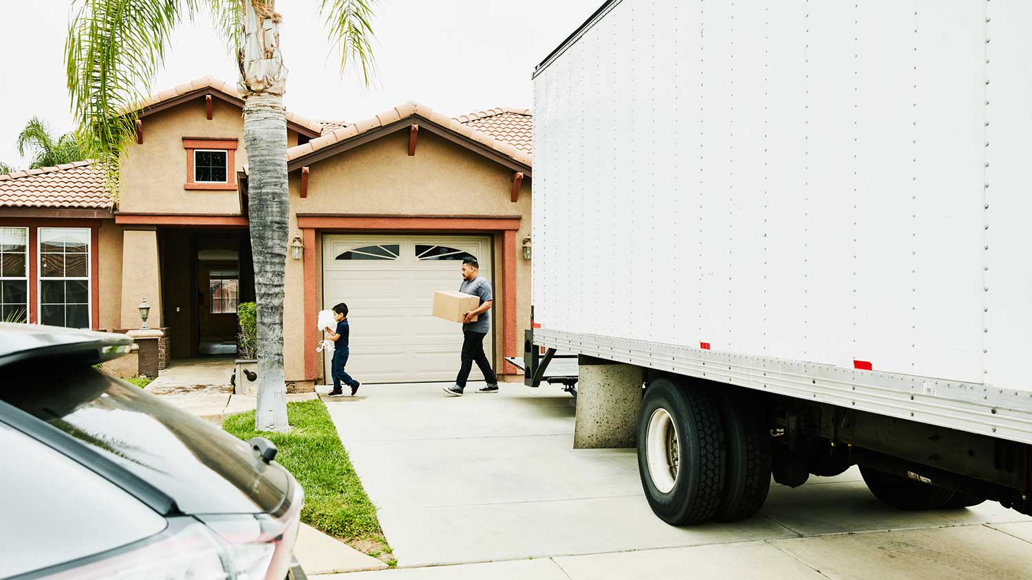 Son helping dad unloading moving truck