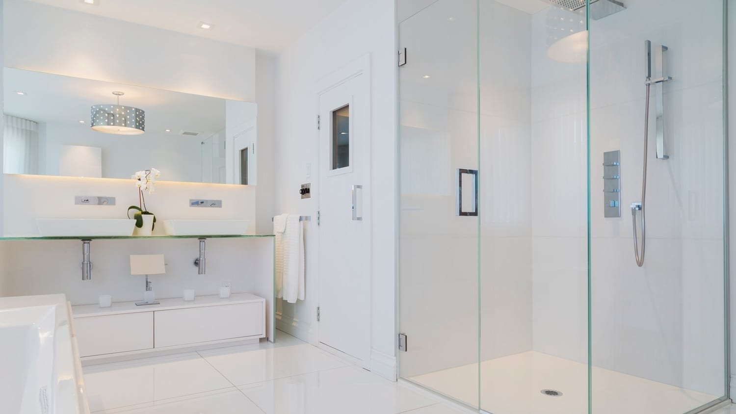 An all-white minimalistic bathroom with a modern shower