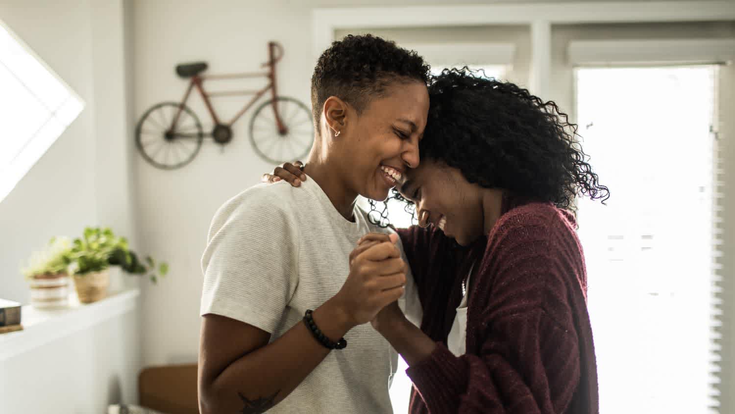 Lesbian couple dancing in living room