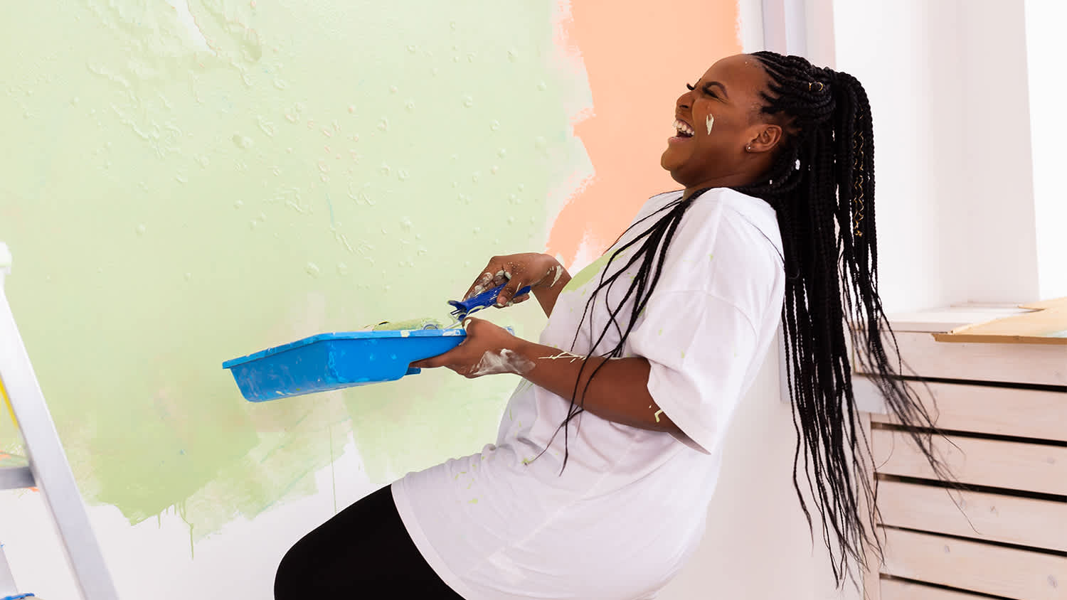 woman having fun painting wall with bright colors