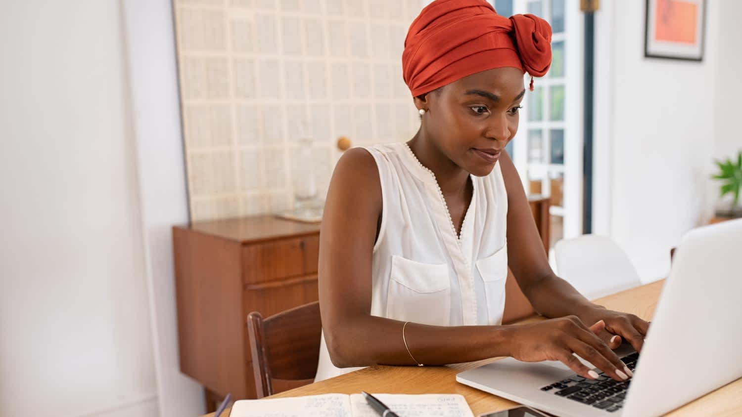 A woman working with her laptop from her home