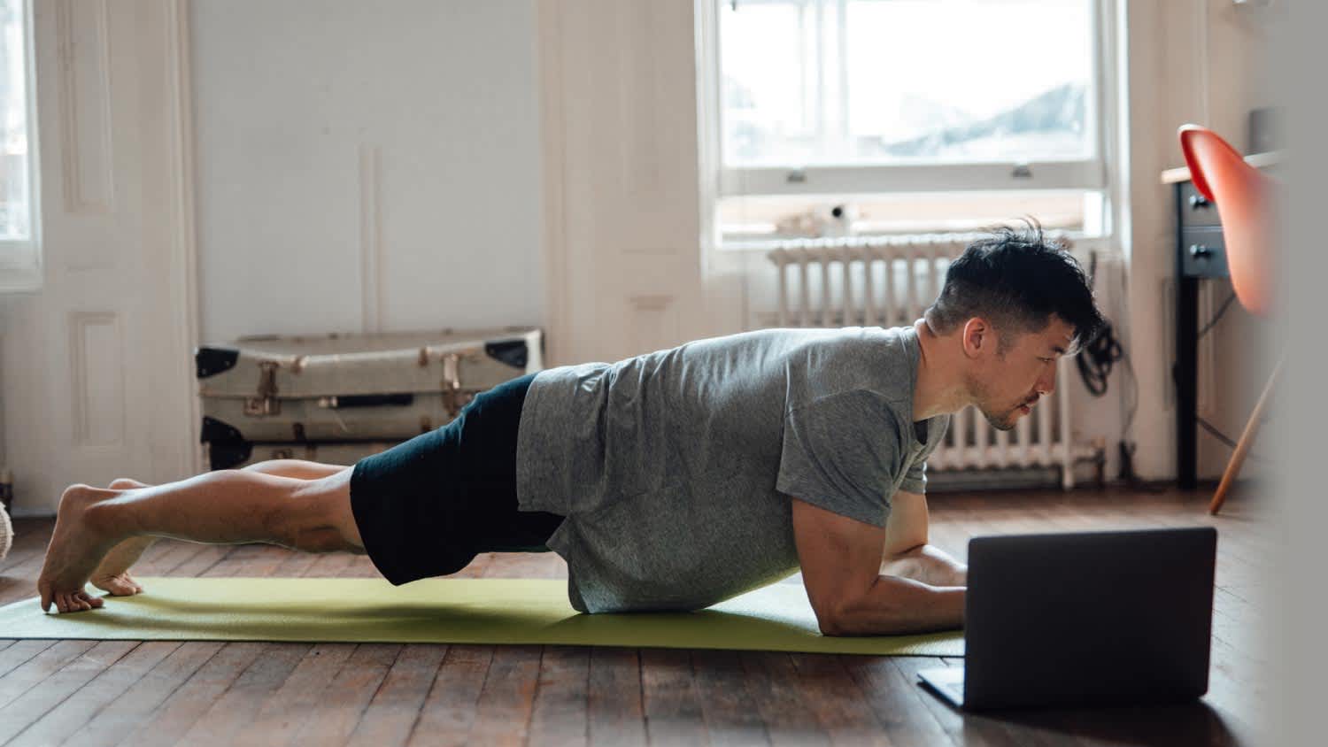A young man in a plank position working out in his home