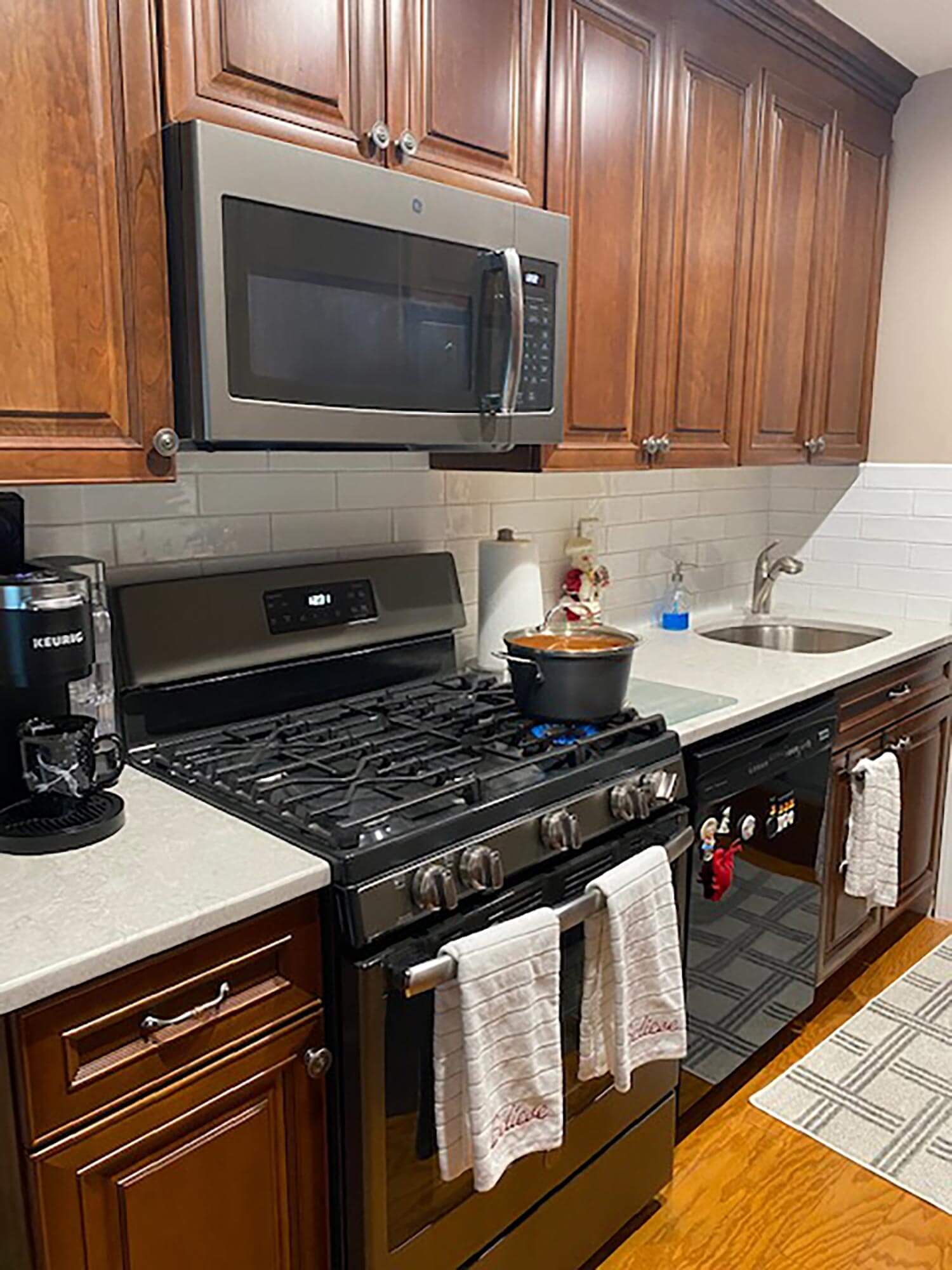 A kitchen with wooden cabinets and white tiles