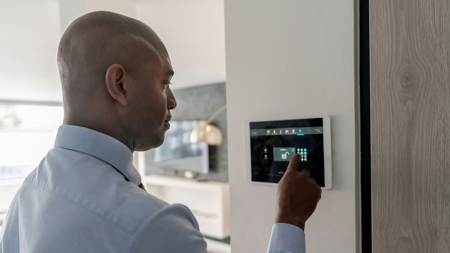 Man adjusting alarm system of his new home