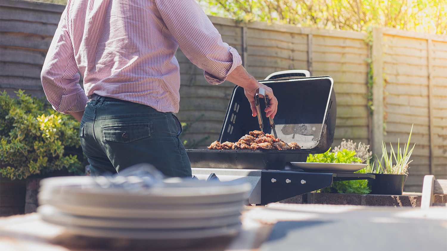 man grilling in his backyard