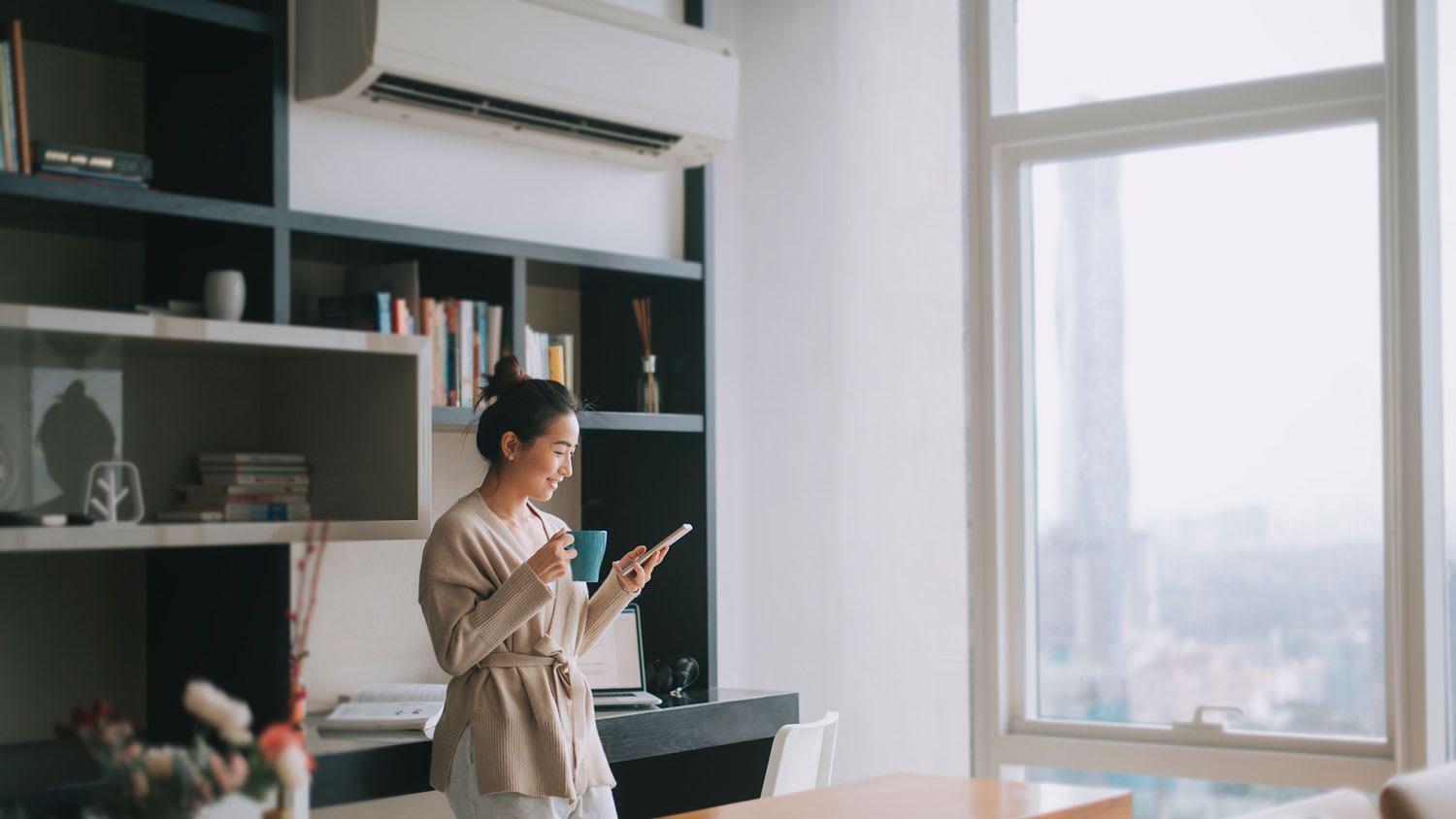 Woman drinking coffee and checking her phone