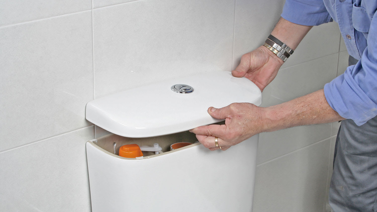 Man removing toilet tank cover