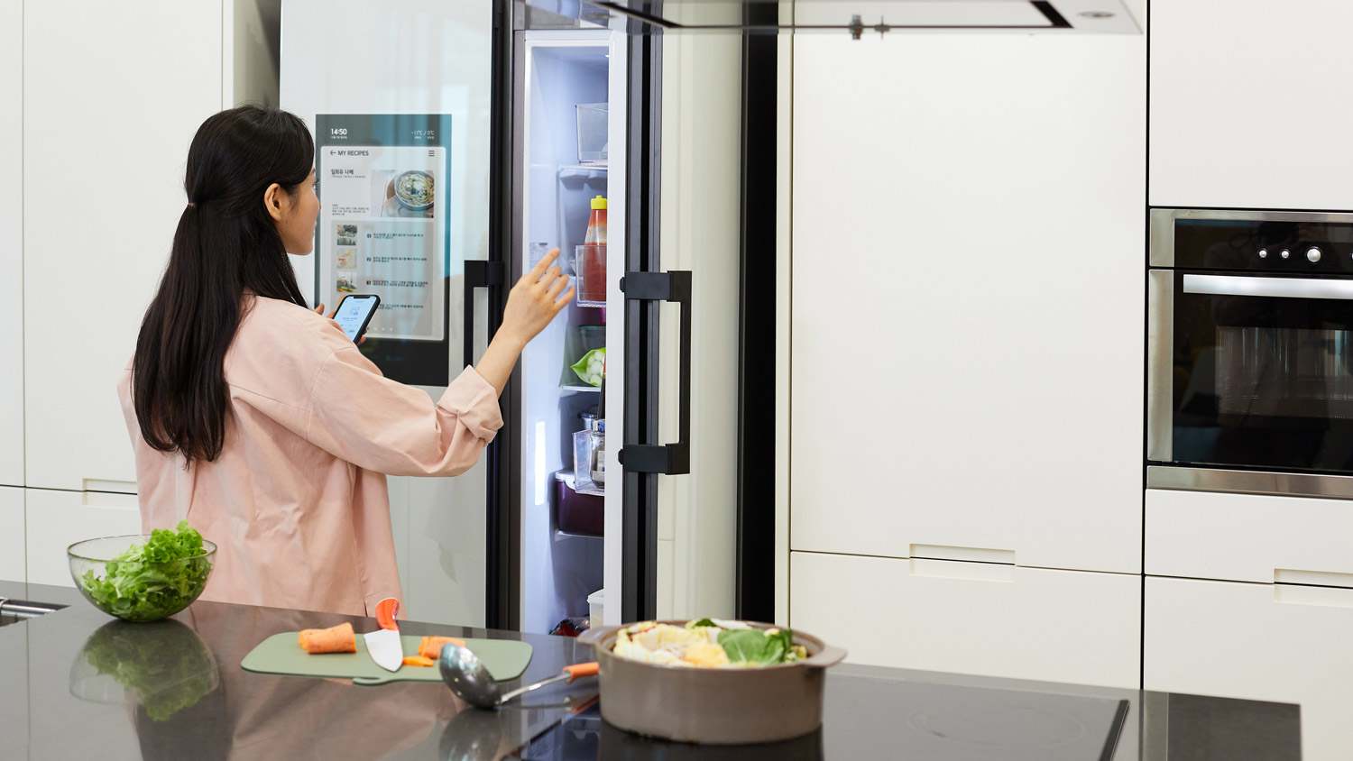 A woman looking in the fridge for expired products