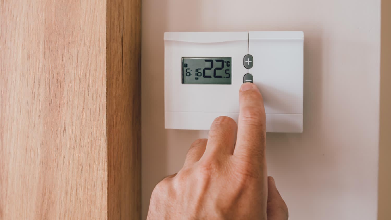 A male hand pushing the button of home heating