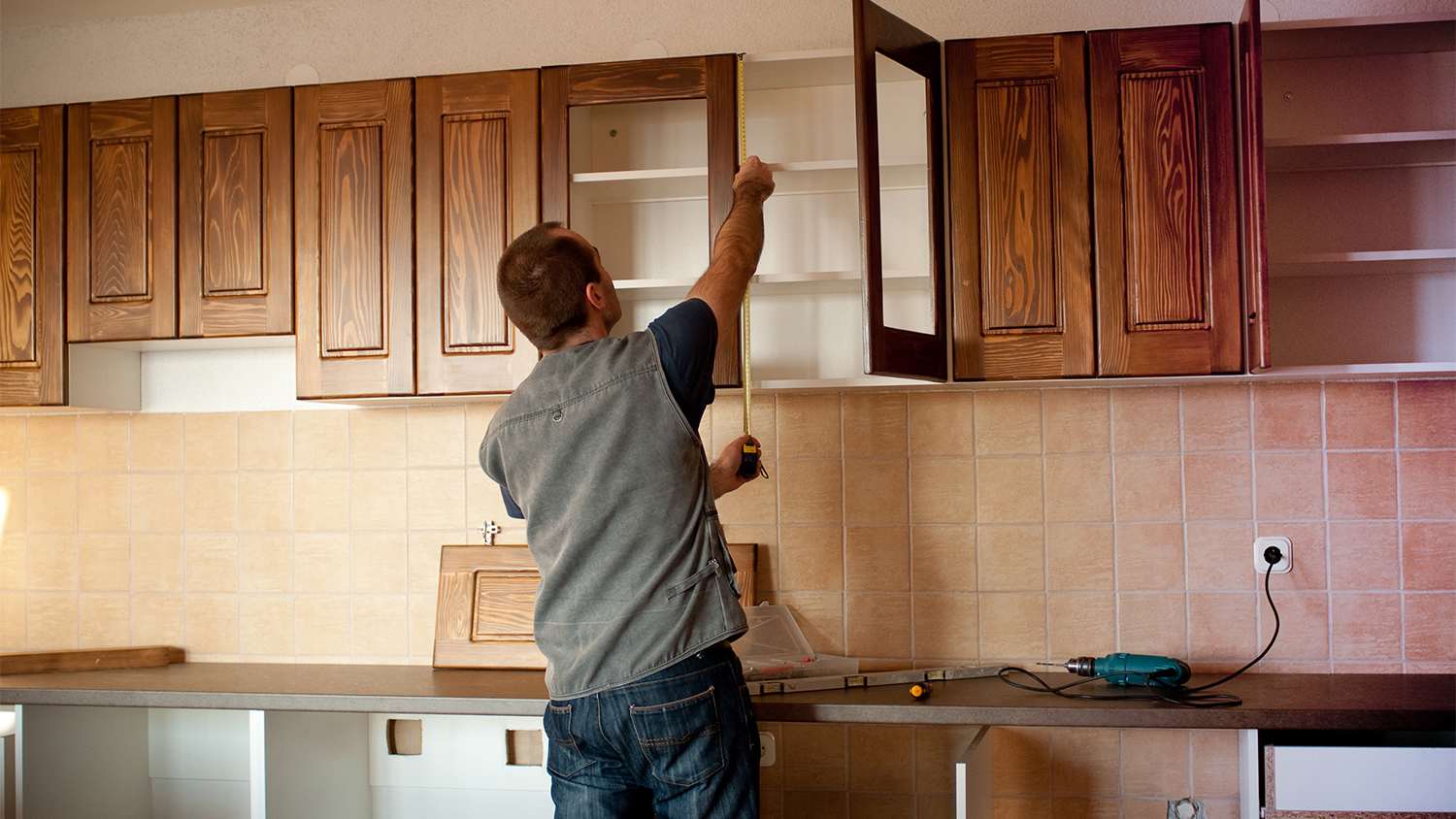 carpenter working on wood cabinets in new home
