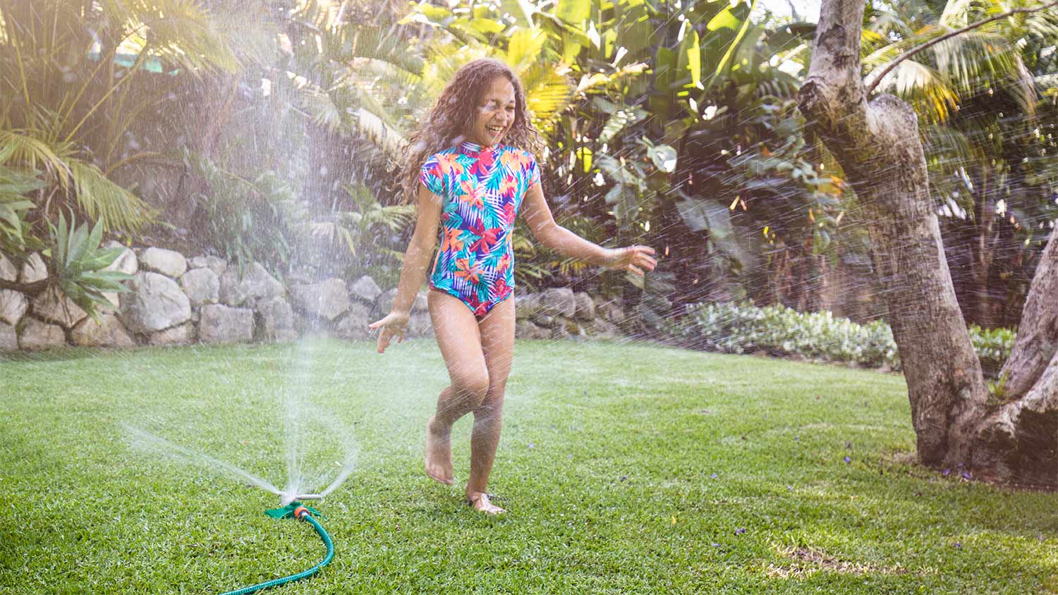 Girl running summer smile sprinkler