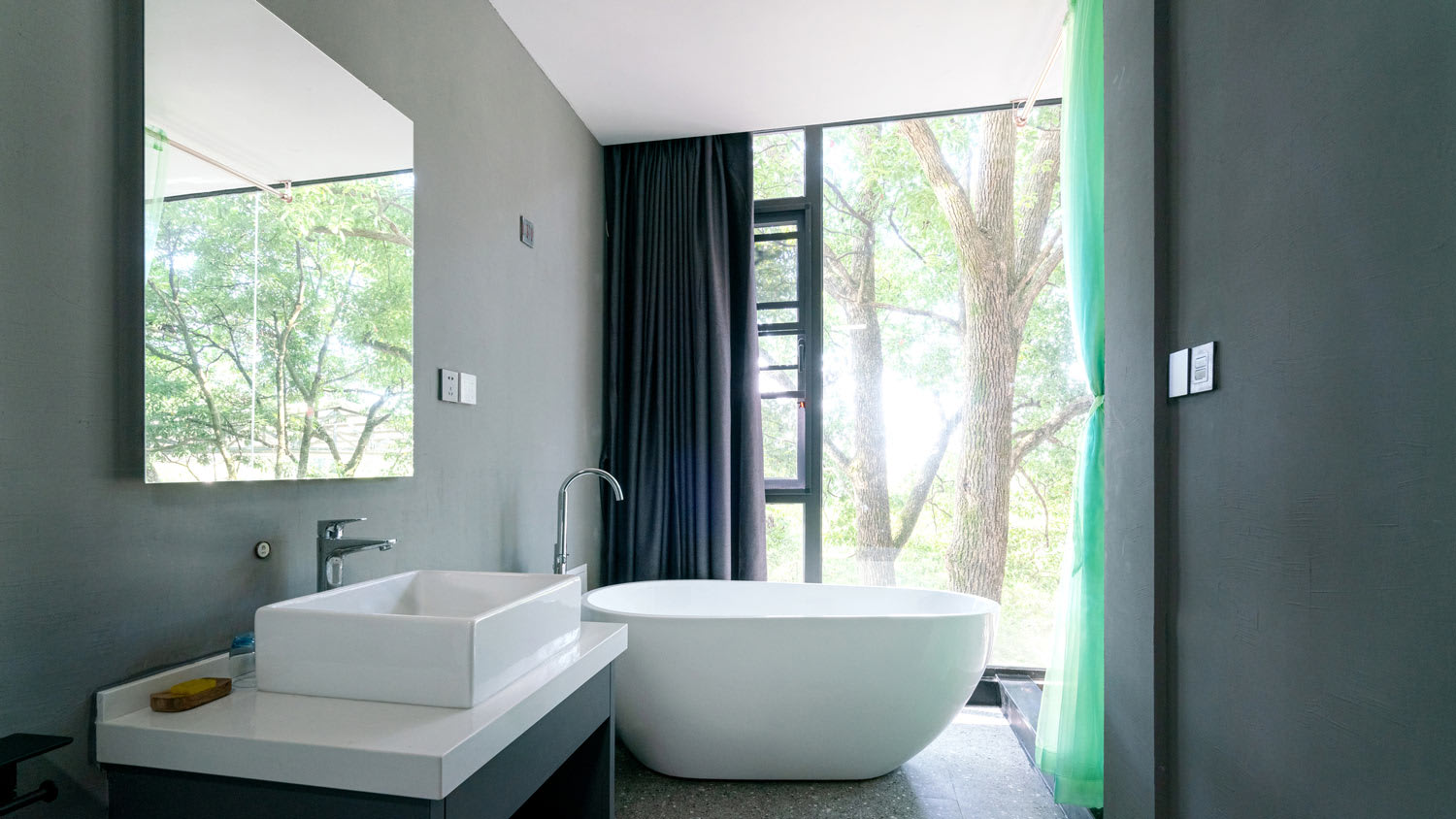 A minimal moody bathroom with a washbasin and a bathtub