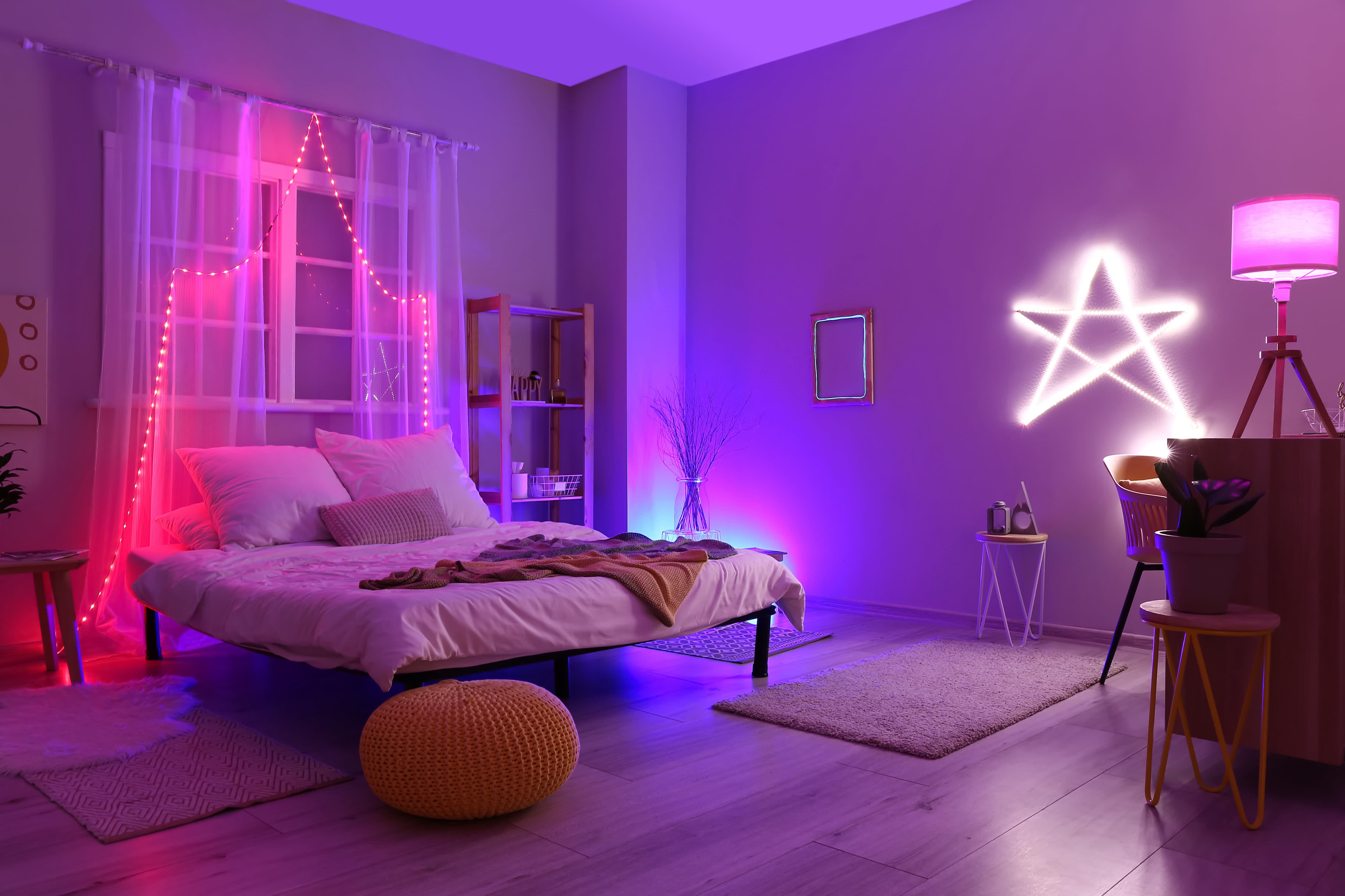 Bedroom with purple neon lighting, red rope lights, and white neon star on the wall