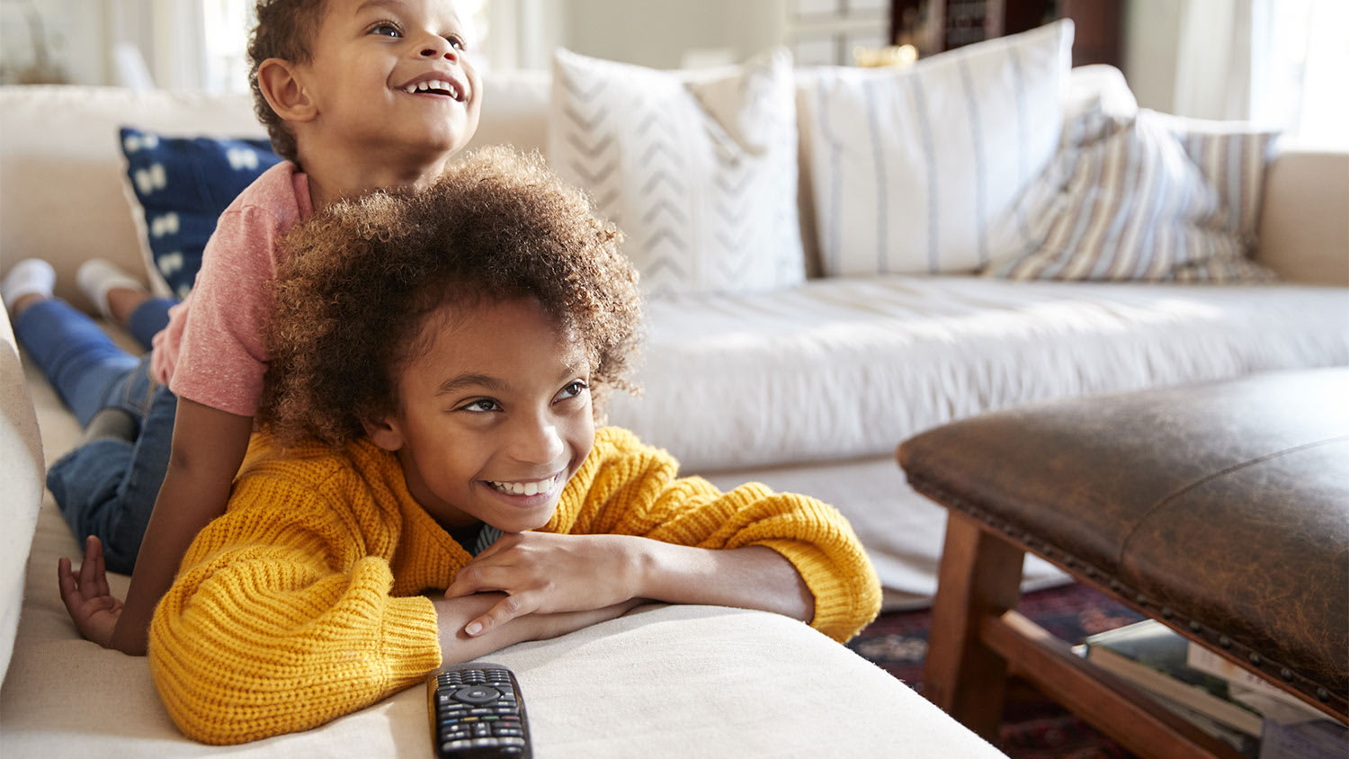 Two kids watching tv on couch