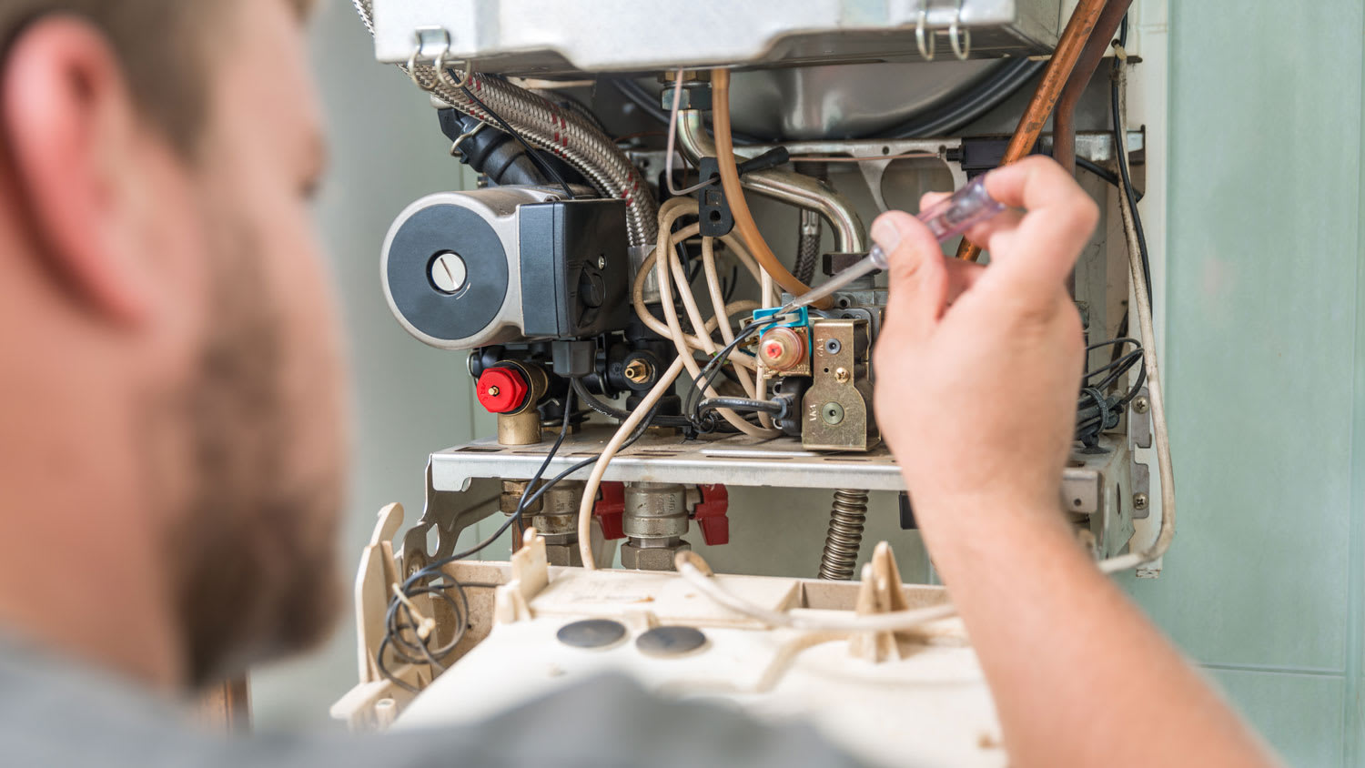 A technician repairing a gas furnace
