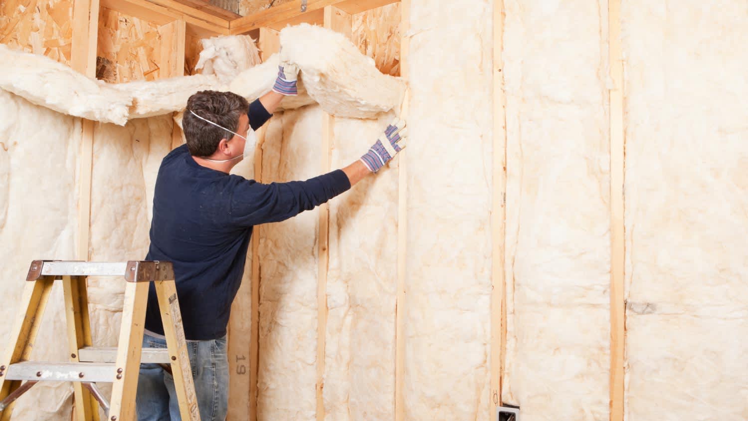A construction worker insulating wall