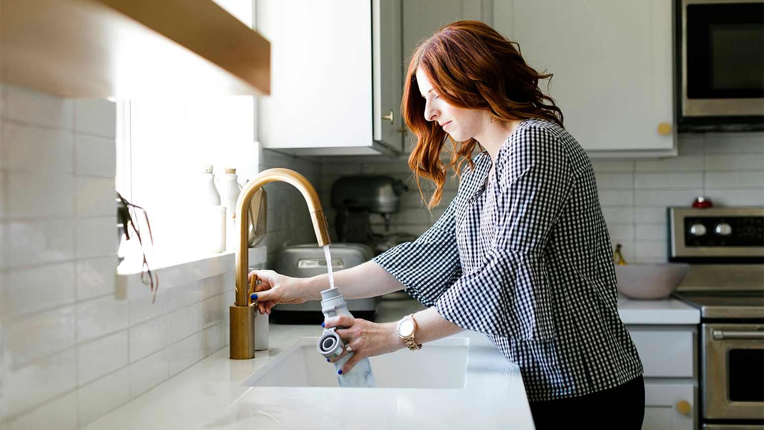 Filling water bottle up at kitchen sink
