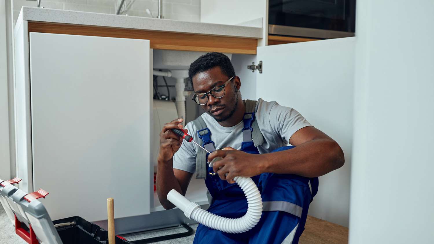 A plumber repairing a kitchen sink